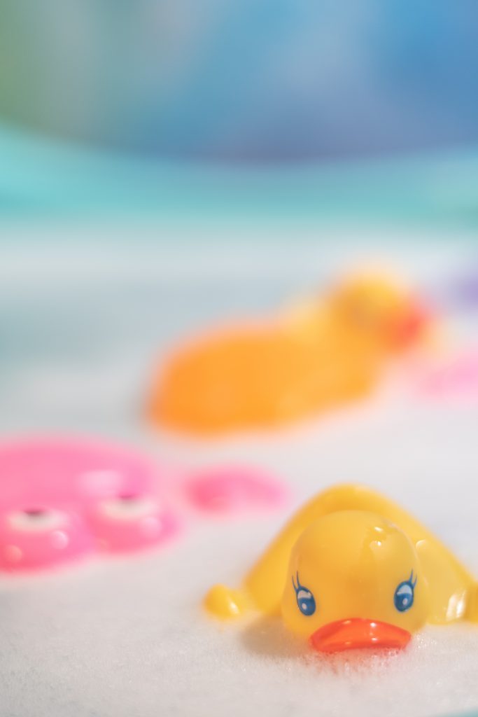 Bubble bath with children's toys in it, a close up of a rubber duck.